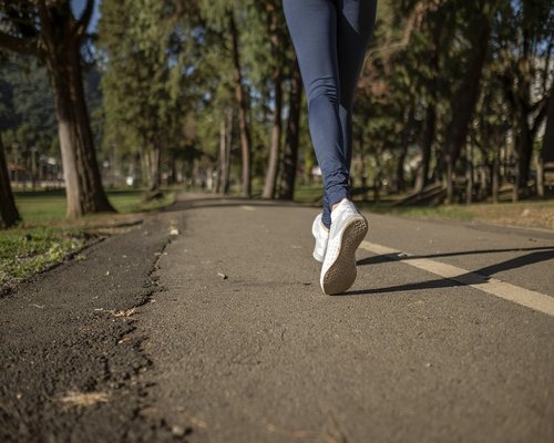 Healthy active lifestyle showing a man jogging through a green forest trail